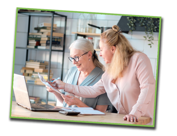 Mother and adult child checking documents in front of laptop.