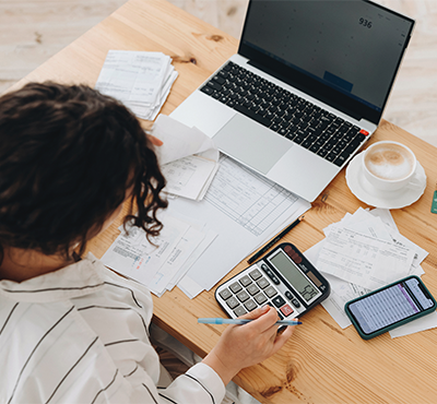 Woman at desk crunching numbers on a calculator