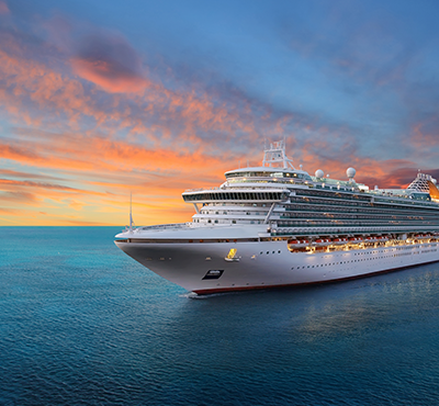 Cruise ship in front of sunset on the ocean.