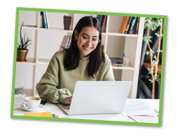 Younger woman smiling while working on her laptop
