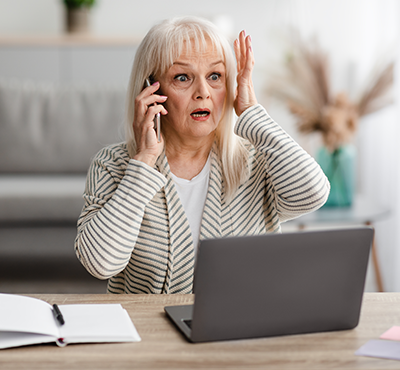 Surprised shocked mature woman talking on mobile phone