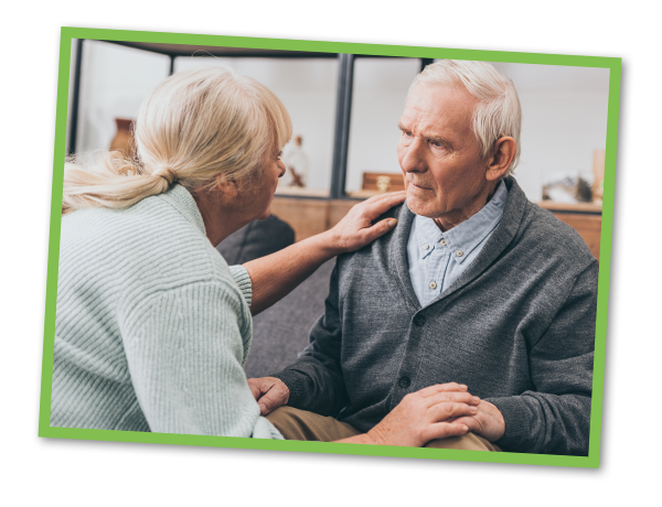 retired couple holding hands and looking at each other at home