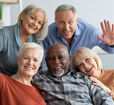 Happy elderly people taking selfie together, home interior
