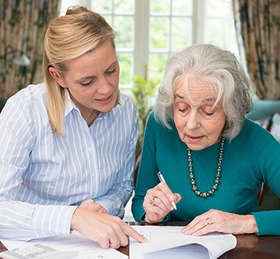Woman helping mother with paperwork.